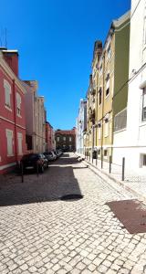 里斯本Belém Apartment的城市中一条鹅卵石街道,有建筑