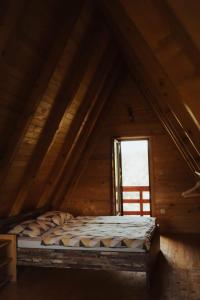 利夫诺Ranč Crna stina的木制客房的一张床位,设有窗户
