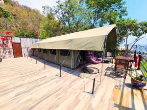 姆万扎Wag Hill Lodge & Spa的甲板上的帐篷,配有桌椅