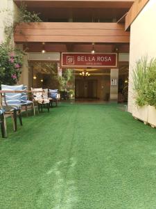 贝鲁特Bella Rosa Hotel的一座建筑,在餐厅前有绿色草坪