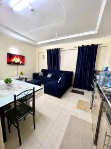BusiaExquisite Modern suite 1bedroom的客厅配有蓝色的沙发和桌子