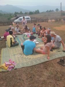 孟丰沙湾Ban Na Pia - Family Home stay的一群人坐在地上的毯子上
