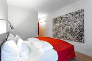 纽伦堡艺术商务酒店的卧室配有一张带红色毯子的白色床