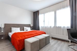 纽伦堡艺术商务酒店的一间卧室配有一张带红色毯子的床和一台电视。