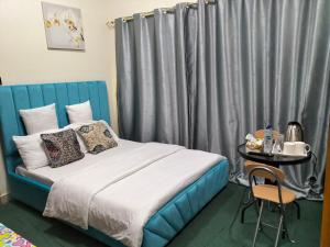 迪拜GRACE BEDSPACE, HOSTEL AND ACCOMODATIONS的一间卧室配有一张带蓝色床头板的床和一张桌子