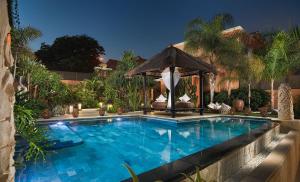阿德耶Royal Garden Villas, Luxury Hotel的房屋旁带凉亭的游泳池