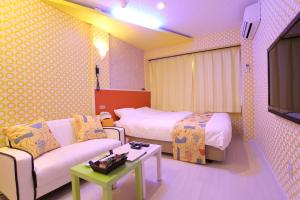 金泽城镇41胶囊旅馆的酒店客房配有床、沙发和电视。