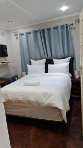 彼得马里茨堡Suprime Hotels and Conference的一间卧室配有一张白色大床和蓝色床头板
