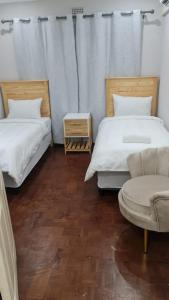 彼得马里茨堡Suprime Hotels and Conference的客房设有两张床、椅子和沙发。