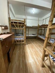 马拉帕斯加Georgia's Neverland Hostel的客房设有三张双层床,铺有木地板。