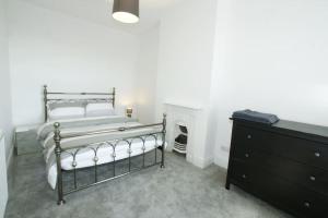 切斯特Modern 4 bed house near city centre/Chester Zoo的一间卧室配有一张床、一个梳妆台和壁炉