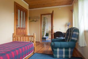 罗亚Viesu māja Vanaturs的一间卧室配有一张床、一张沙发和一把椅子