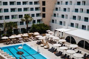 埃拉特阿特拉斯诺瓦莱克酒店的酒店旁的游泳池配有躺椅和遮阳伞