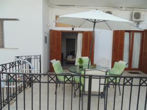 斯基亚索斯镇玛丽亚一室公寓的阳台配有桌椅和遮阳伞