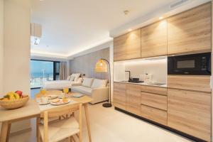 加的斯Apartamentos Playa Victoria的厨房以及带桌子和沙发的客厅。