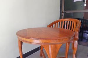 诗都阿佐OYO Life 92915 Duta Amnan Syariah的一张木桌和椅子坐在墙上