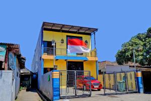 诗都阿佐OYO Life 92915 Duta Amnan Syariah的阳台上带有国旗的黄色建筑