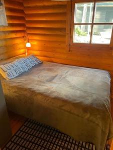 纳坦利Rantahuvila Naantalissa的木制客房的一张床位,设有窗户