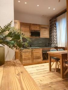 布勒伊-切尔维尼亚Fior di Roccia Apartments的厨房配有木制橱柜和木桌。