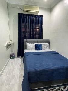 瓜拉丁加奴AR HOMESTAY KUALA TERENGGANU的一间卧室配有一张蓝色的床和窗户