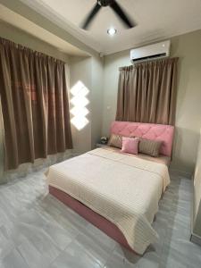 瓜拉丁加奴AR HOMESTAY KUALA TERENGGANU的一间卧室配有一张带粉红色床头板的大床