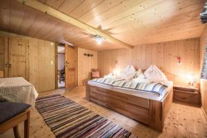施瓦茨Alpenzauber / Chalet AlmZeit / Almhütte Zillertal的一间带一张大床的卧室,位于带木墙的房间