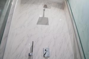 阿布贾MercuryIcon luxury Homes的浴室内有标志的白色大理石墙