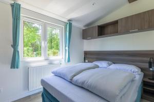 克拉亨堡Recreatiepark de Voorst的带窗户的客房内的两张床
