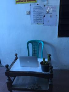 诗都阿佐OYO Life 93009 Griya Nautika Sedati的手提电脑和盆栽的椅子