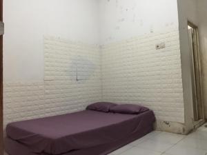 诗都阿佐OYO Life 93009 Griya Nautika Sedati的一间位于角落的带紫色床的卧室