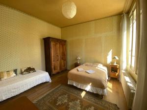 欧塞尔La maison familiale的一间卧室设有一张床和一个窗口