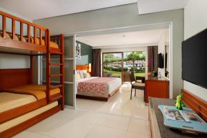 库塔巴厘岛王朝假日酒店的一间带双层床的卧室和一间客厅