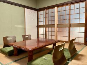 北九州Nostime lodge 女性限定 female only的一间带木桌和椅子的用餐室