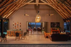 侯斯普瑞特Tomo Safari Lodge的大型客厅设有木梁天花板