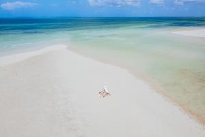 DikoniYcona Eco-Luxury Resort, Zanzibar的坐在海洋白色沙滩上的船
