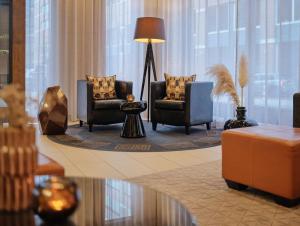 汉堡汉堡米歇尔阿迪娜公寓式酒店的大堂设有两把椅子、一张桌子和一盏灯