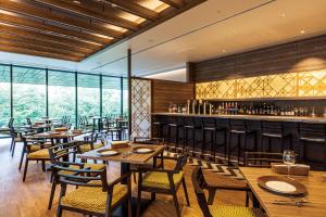 东京京阪築地银座格兰德酒店的一间带木桌椅的餐厅和一间酒吧
