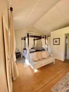 温特和克Out Of Nature Country Lodge的客厅配有白色的沙发和床。