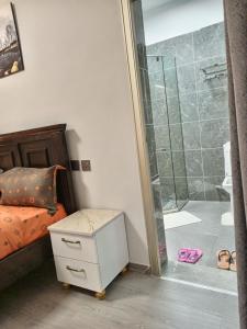 内罗毕New 2 & 3 bedroom Apartment in Kilimani Nairobi with rooftop pool的一间卧室设有一张床和一个玻璃淋浴间