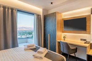 约阿尼纳CITY HILL Luxury Apartments的配有一张床、一张书桌和一扇窗户的酒店客房