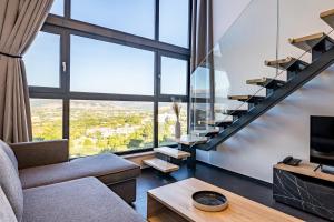 约阿尼纳CITY HILL Luxury Apartments的客厅设有楼梯和大窗户