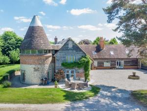 奥尔顿The Oast House - Hartley Wine Estate的一座古老的石头房子,有一个塔楼和一个院子