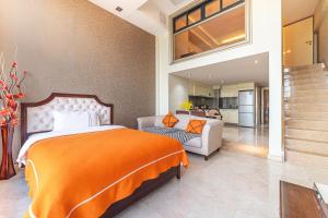 广州广州正佳金殿维福顿公寓（广交会期间免费穿梭巴士）的一间带橙色床的卧室和一间客厅