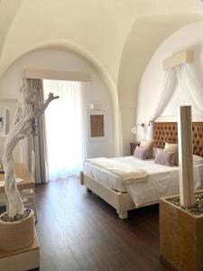 格拉维纳普利亚IL Borgo Relais的一间卧室设有一张床和一个大窗户