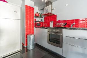 勒格罗-迪鲁瓦appartement de la barque bleue的墙壁上铺有红色瓷砖的厨房