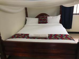 卡巴莱The Fortuna Apartment的一张带白色床单和枕头的床