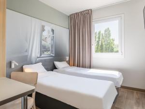 沃内勒B&B HOTEL Aix en Provence Venelles的带窗户的客房内的两张床
