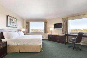 莱斯布里奇莱斯布里奇戴斯酒店的酒店客房配有一张床、一张书桌和一台电视。