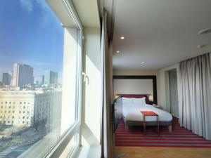 华沙华沙美居大酒店的一间卧室设有一张床和一个大窗户