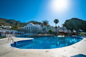 内尔哈Apartamentos & SPA Torres de San Juan的蓝色海水度假村的游泳池